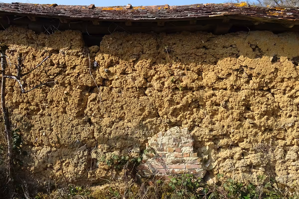 Vestige d’un mur en torchis délimitant divers espaces jardinés ou paysagers sur les terres d’un château dans l’Orne.